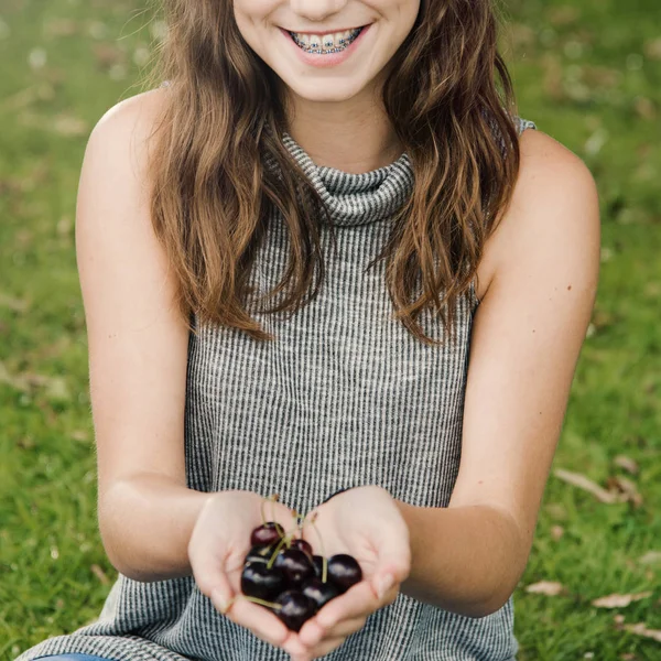 Chica sosteniendo cerezas frescas —  Fotos de Stock