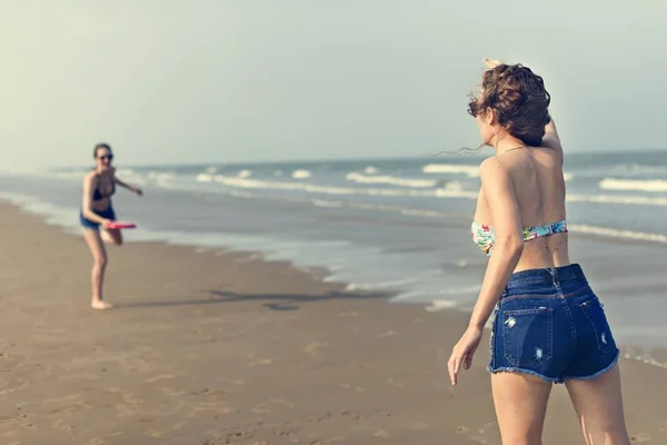 Meisjes spelen Frisbee op strand — Stockfoto
