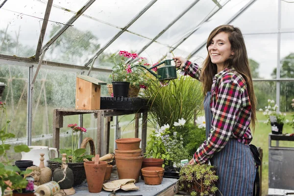 Mulher regando flores e plantas — Fotografia de Stock