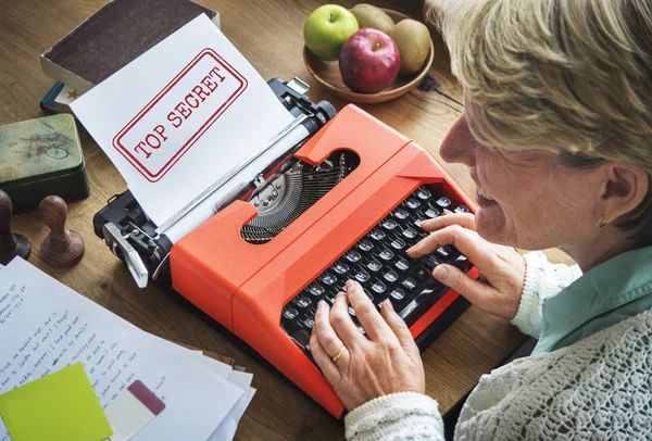 Senior Kvinna skriver på skrivmaskin maskin — Stockfoto