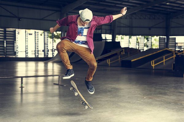 Молодой человек прыгает со скейтборда
