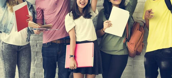 Students standing against white wall — Stock Photo, Image