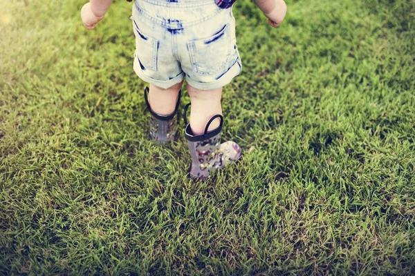 Pequeño niño caminando sobre hierba verde — Foto de Stock