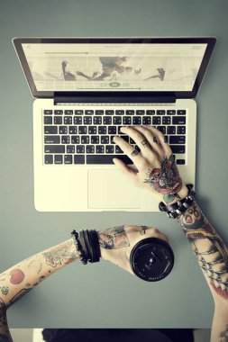 dizüstü bilgisayarda yazarak dövmeler elinde 