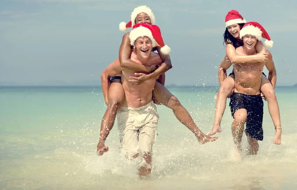 Couples in santa hats on Beach — Stock Photo, Image