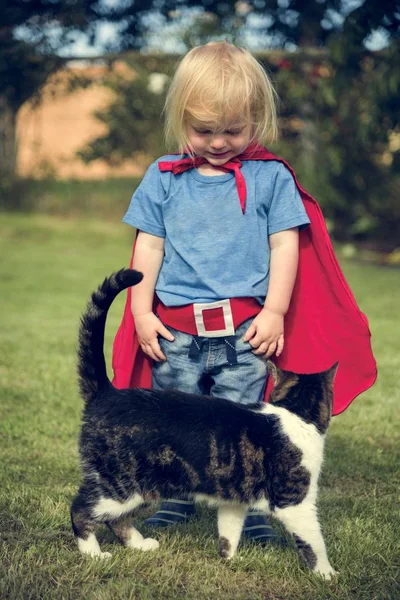 Superhero Boy brincando com gato — Fotografia de Stock