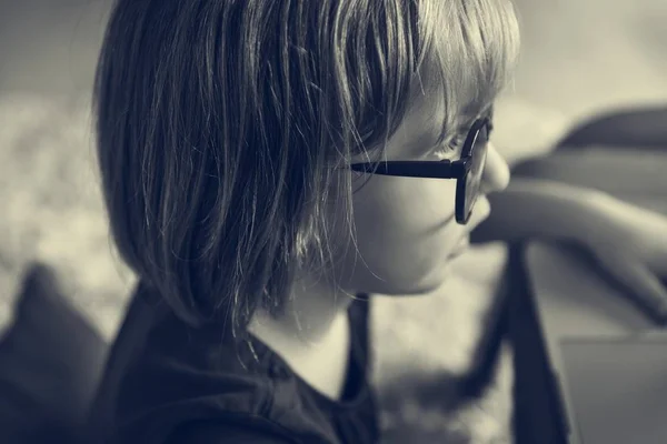 Niña en gafas usando el ordenador portátil — Foto de Stock