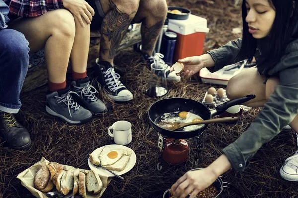 Amigos comendo alimentos no acampamento — Fotografia de Stock