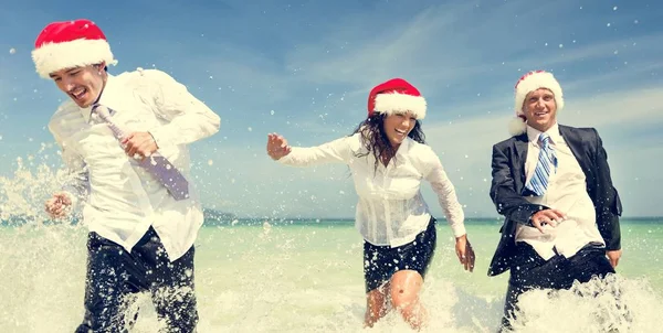 Collega's in Santa hoeden met vakantie — Stockfoto