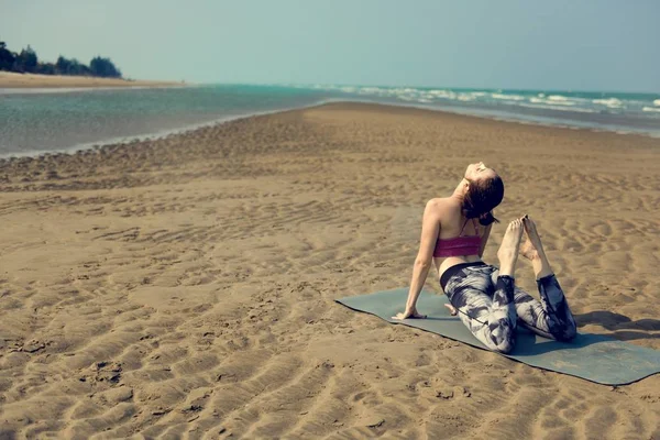 Женщина занимается йогой на пляже — стоковое фото