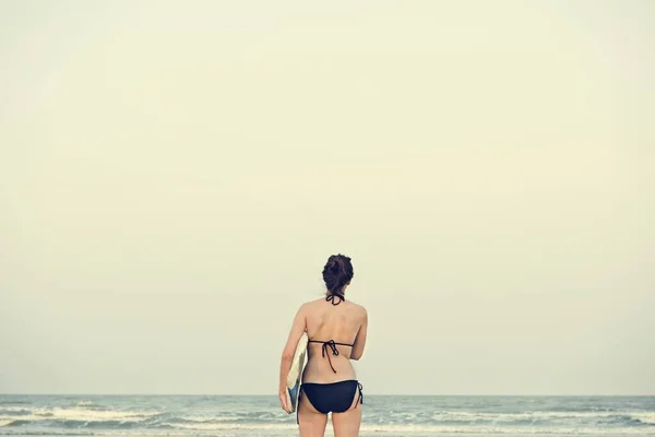 Γυναίκα με σανίδα του σερφ στην παραλία — Φωτογραφία Αρχείου