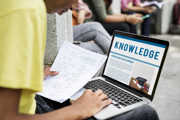 Student met behulp van laptop in straat — Stockfoto