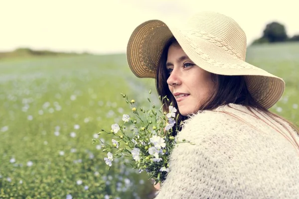 Mooie vrouw zitten in veld — Stockfoto