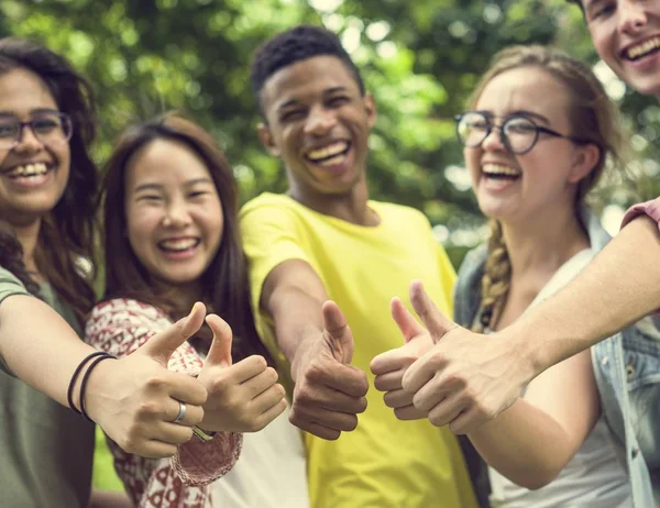 Jóvenes estudiantes con pulgares arriba — Foto de Stock