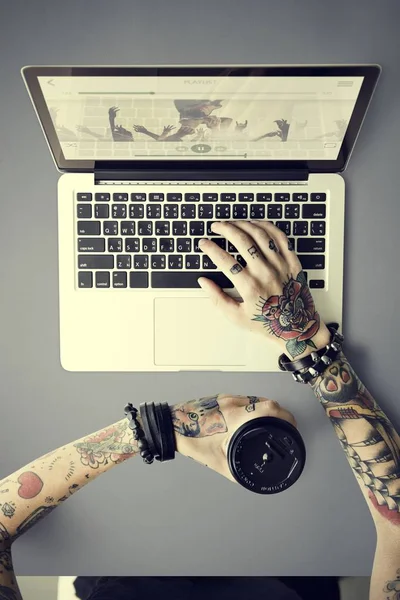 Ręce w tatuaże pisania na laptopa — Zdjęcie stockowe