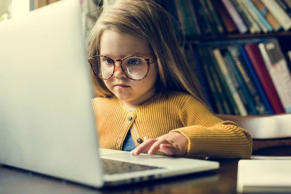 Маленькая девочка с помощью ноутбука — стоковое фото