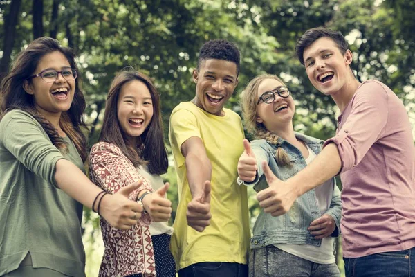 Unga studenter med tummen upp — Stockfoto