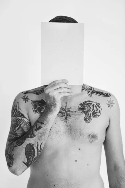 Człowiek z tatuażami, trzymając papier — Zdjęcie stockowe