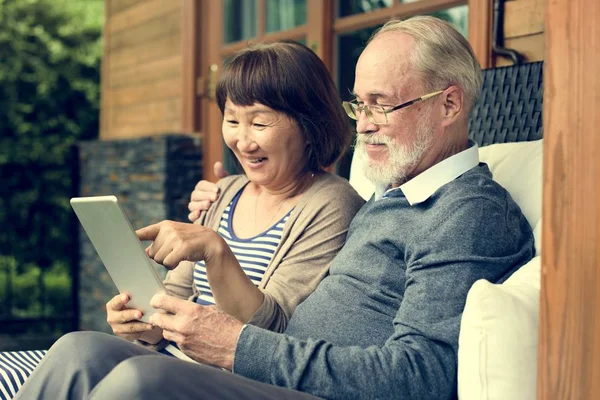 Personas mayores que usan tabletas en casa — Foto de Stock