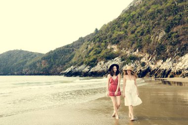 Kumsalda elbiseler giyen kızlar