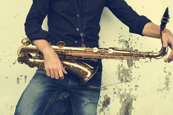 Muzikant holding saxofoon — Stockfoto