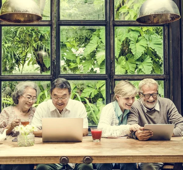 Amici anziani che utilizzano dispositivi digitali — Foto Stock