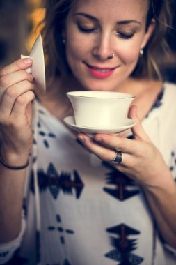 Genç bayan çay içiyor.