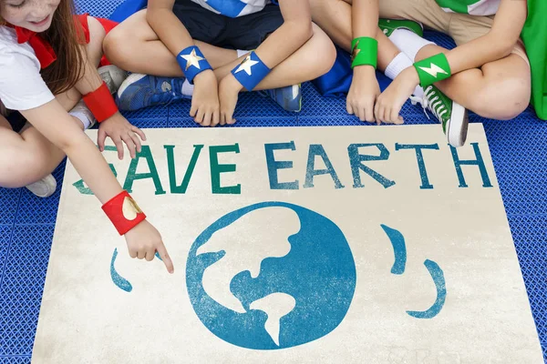 Superhéroes niños sentados en el suelo con cartel — Foto de Stock