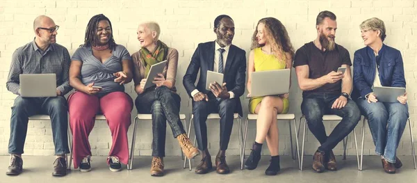 Menschen sitzen auf Stühlen — Stockfoto