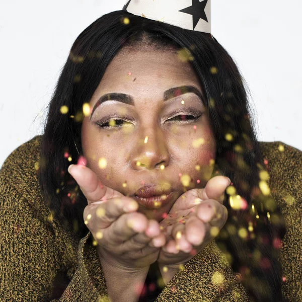 Femme africaine soufflant confettis étincelants — Photo