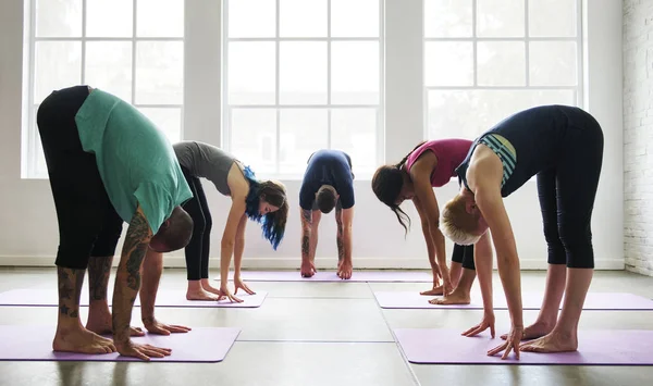 Människor som gör yoga praxis i klass — Stockfoto