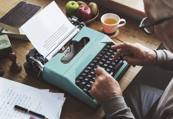 年配の男性がタイプライターのマシン上の書き込み — ストック写真