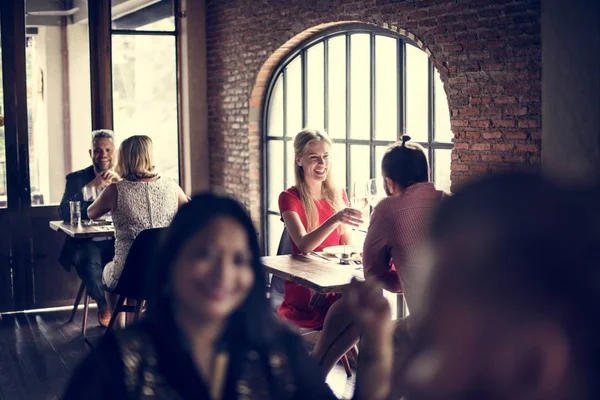 Personas sentadas a la mesa en el restaurante — Foto de Stock