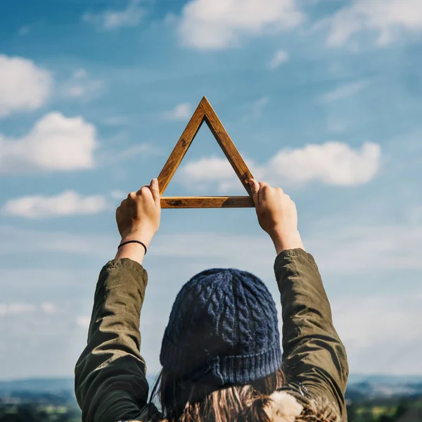 Женщина держит деревянный треугольник — стоковое фото