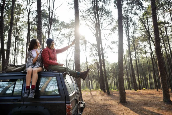 Paar zittend op auto in bos — Stockfoto