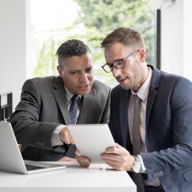 dizüstü bilgisayar kullanan işadamları