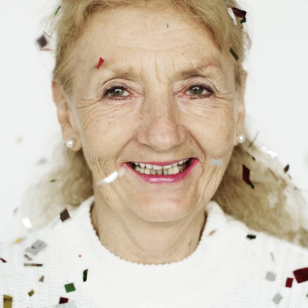 Старшая женщина и красочные конфетти — стоковое фото