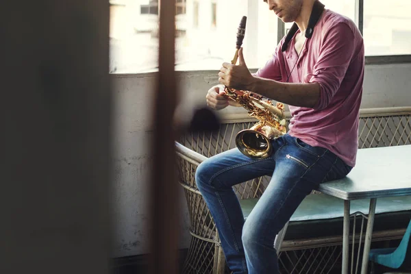 Музыкант, держащий саксофон — стоковое фото