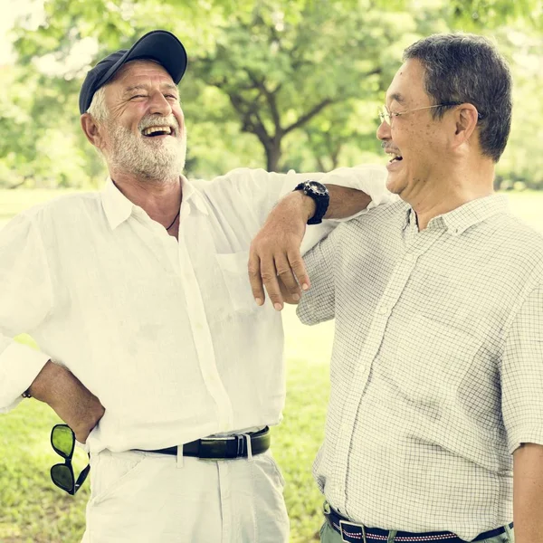 Mature Friends talking at park — Stock Photo, Image