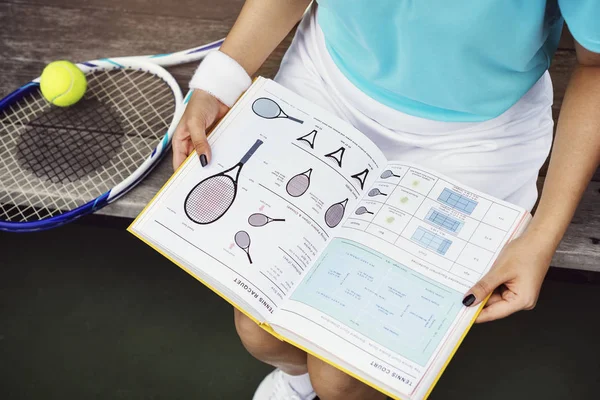 Woman Reading Book about Tennis