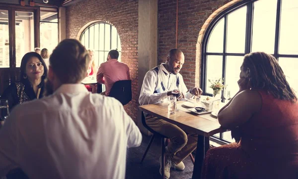 Grupo de pessoas sentadas à mesa no restaurante — Fotografia de Stock