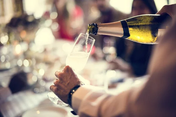 De ober giet champagne in een glas — Stockfoto