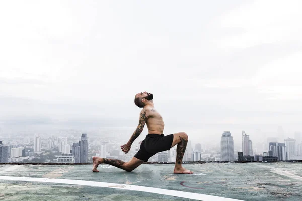 Hombre haciendo ejercicio en la azotea — Foto de Stock