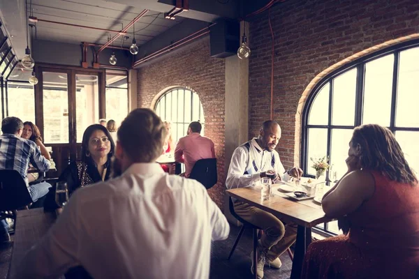 Grupo de pessoas sentadas à mesa no restaurante — Fotografia de Stock