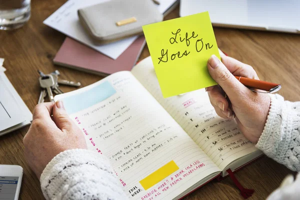 Persona sosteniendo nota de palo amarillo — Foto de Stock