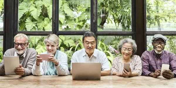 Amici anziani che utilizzano dispositivi digitali — Foto Stock