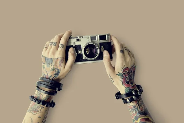 Ręce w tatuaże posiada aparat fotograficzny — Zdjęcie stockowe