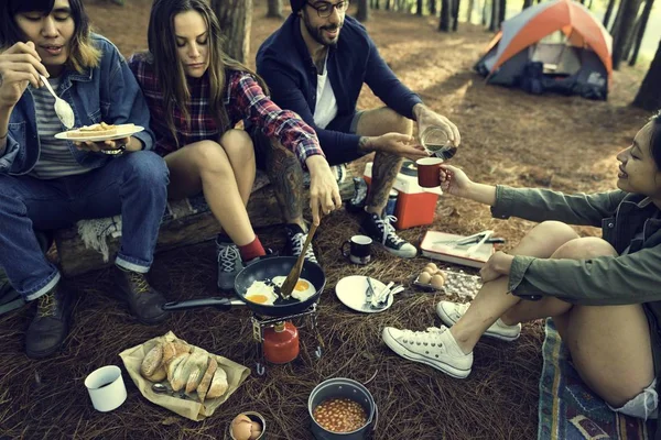 Amici che mangiano e bevono in campeggio — Foto Stock