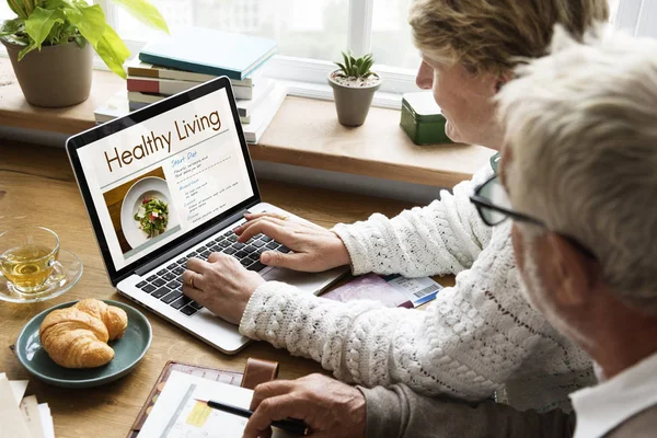 Couple using laptop at workplace table — Stock Photo, Image