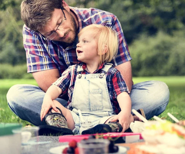 Far och son njuter picknick — Stockfoto